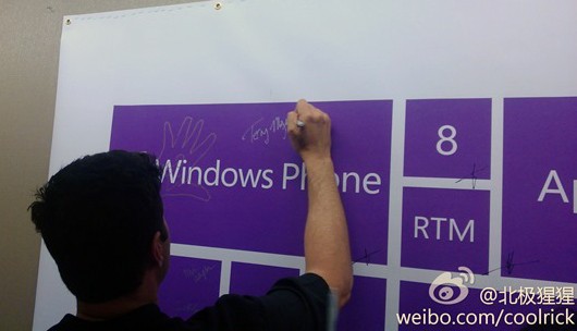 Employé de Microsoft signant l'affiche de la RTM de Windows Phone 8